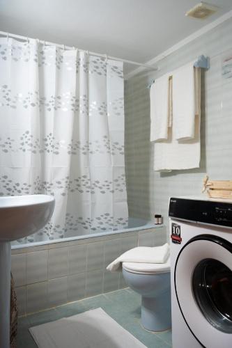 a bathroom with a toilet and a washing machine at Central Boutique Apartment Gythio in Gythio