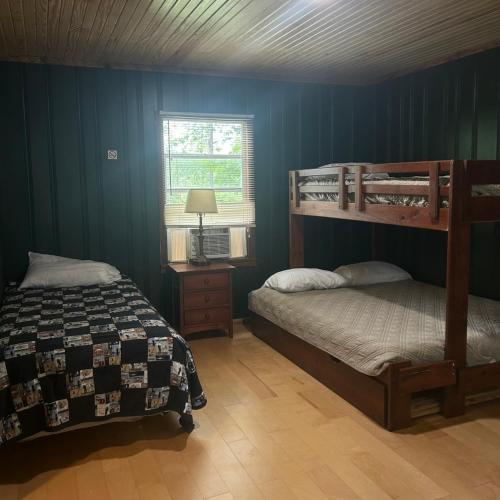 two bunk beds in a bedroom with blue walls at Cabin #1 on Meramec River in Steelville