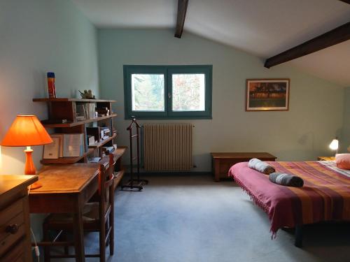 a bedroom with a bed and a desk and a window at Boningal in Moissac