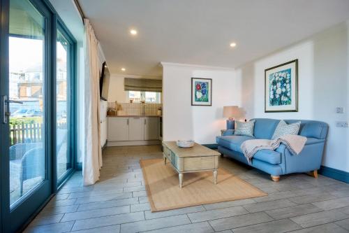 a living room with a blue couch and a table at Le Strange Arms Garden Lodges in Hunstanton
