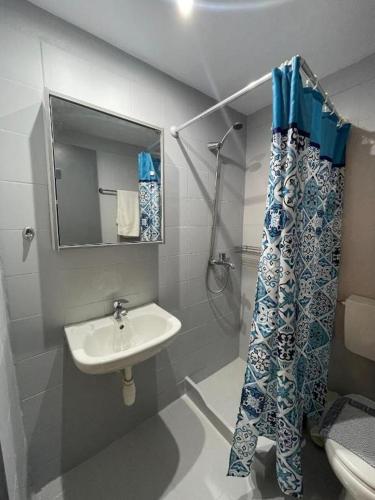 a bathroom with a sink and a shower curtain at Sidari Vibes Aparthotel in Sidari
