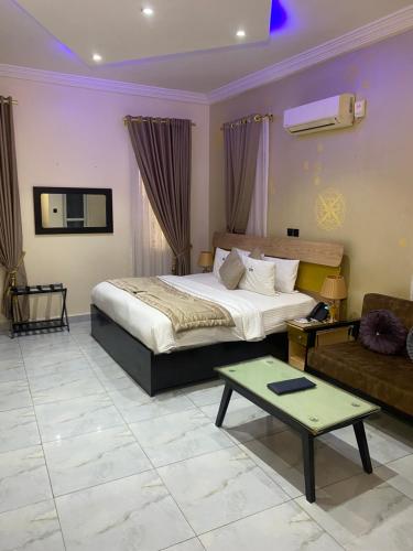 ein Hotelzimmer mit einem Bett und einer Couch in der Unterkunft Providha Hotel & Suites in Ikeja