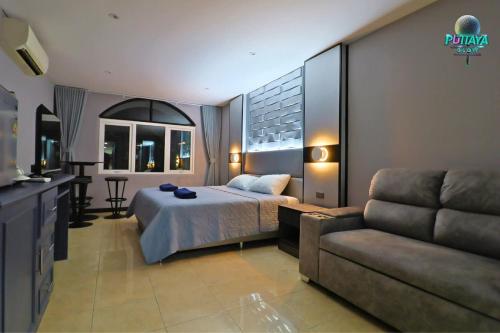 a hotel room with a bed and a couch at Puttaya Glow in Pattaya