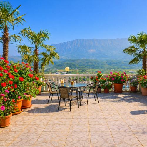 a patio with a table and chairs and flowers at Guest house Memushi in Gjirokastër