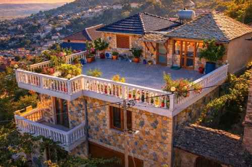 a house with a balcony with flowers on it at Guest house Memushi in Gjirokastër