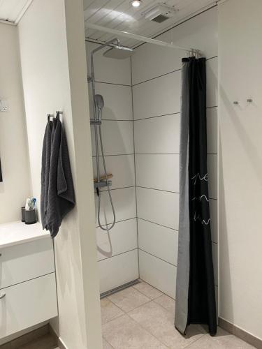 a shower in a bathroom with a black shower curtain at Lille hus i Sydbyen in Silkeborg