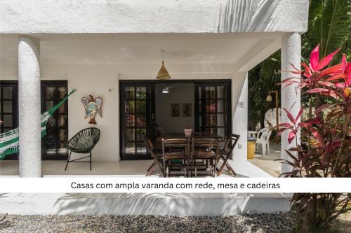 a view of a house with a table and chairs at Cond Vista Hermosa - Casas para famílias 2 quartos in Pipa