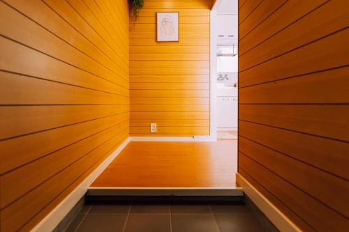 a hallway with wood paneled walls and a wooden floor at Chic Nakasu Apartment Perfect for 2 Guests in Fukuoka