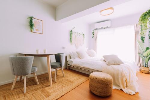 a bedroom with a bed and a table and chairs at Chic Nakasu Apartment Perfect for 2 Guests in Fukuoka