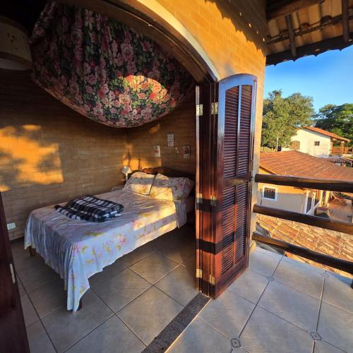 a bedroom with a bed on a balcony at Pousada Cantinho das Fadas in Conceição da Ibitipoca