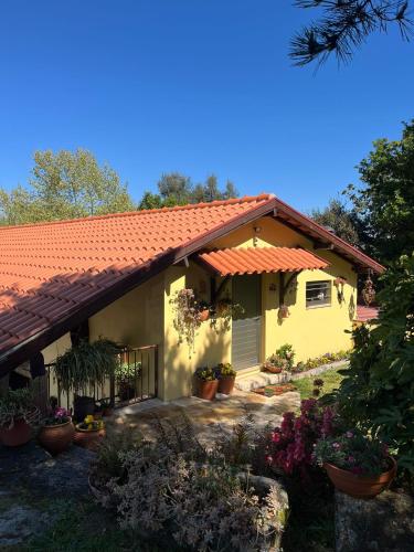 a yellow house with an orange roof at Quinta de Carcavelos Agroturismo e Enoturismo in Celorico de Basto