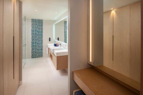 ein Badezimmer mit Waschbecken und Spiegel in der Unterkunft OZO Phuket in Kata Beach