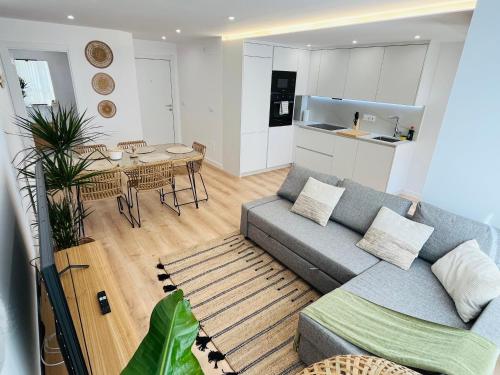 a living room with a couch and a table and a kitchen at RÍA LIVING - Arena 01 in Cee