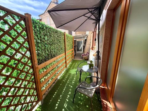 a balcony with a table and an umbrella at Appartamento al volt in Tenno