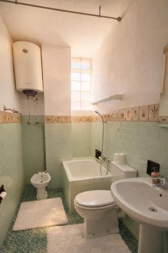 a bathroom with a toilet and a sink and a tub at Iris Peaceful Apartment near Lake Como and Lugano in Lanzo dʼIntelvi