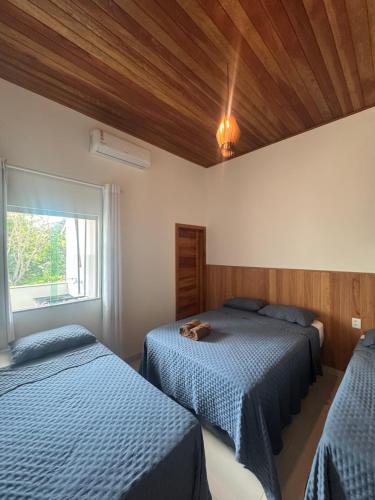 a bedroom with two beds and a cat laying on the bed at Flat Bluvi Centro de Barra-Grande in Marau