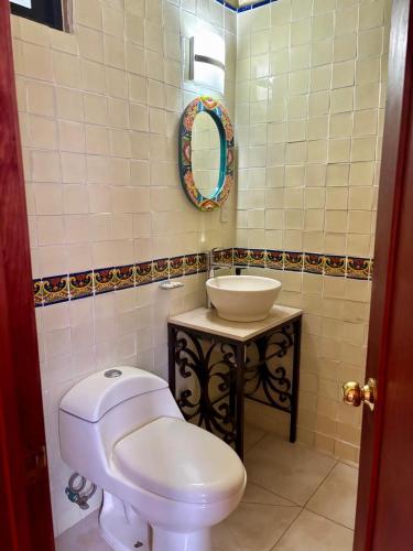 a bathroom with a white toilet and a sink at Hotel-Posada Kali Tlayacapan in Tlayacapan