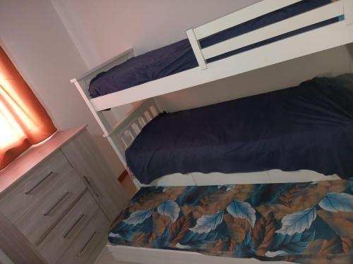 a bedroom with two bunk beds and a dresser at Solanas tanti in Tanti