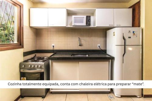 a kitchen with a refrigerator and a stove and a microwave at Solar Pipa by Pipa Centro in Pipa