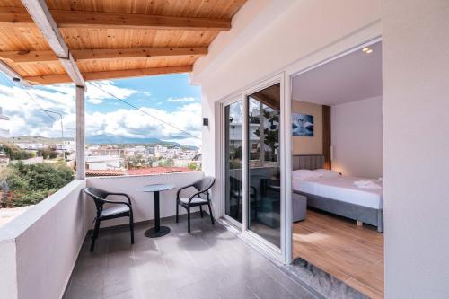 a room with a balcony with a bed and a table and chairs at Velora Apartments Ksamil in Ksamil