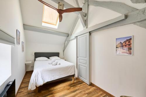a bedroom with a bed and a ceiling fan at Le Bossuet - Cosy et Charme au Centre Historique in Dijon