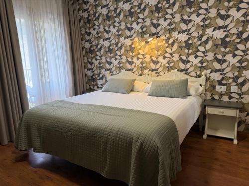 a bedroom with a bed with a flower patterned wall at Edelweiss Hotel in Torla-Ordesa