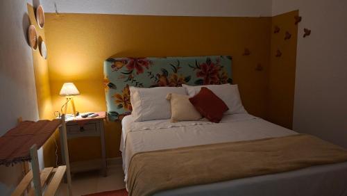 a bedroom with a bed with a headboard and a table at Costamar Galinhos in Galinhos