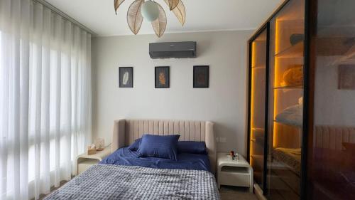 a bedroom with a bed with blue sheets and a window at Boho sokhna families only in Ain Sokhna