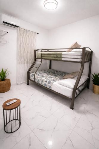 a bedroom with two bunk beds and a stool at La Casita del Este in Fajardo