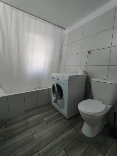 a bathroom with a toilet and a washing machine at comfortable room and shared kitchen and bathroom in Athens