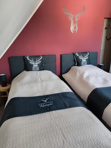 two beds in a room with a red wall at Ferienwohnung Kampić Turmblick in Rottweil