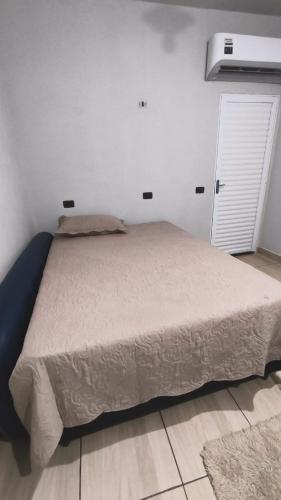 a bed in a bedroom with a white wall at Área de Lazer BR 267 in Bataguaçu