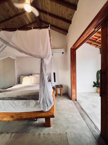 a bedroom with a bed with a canopy at CASA SIMONI Trancoso in Trancoso