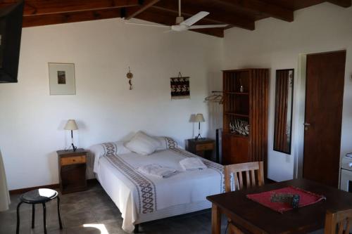 a bedroom with a white bed and a table and a table sidx sidx at Cabañas Tinku del Sol in Casa Grande