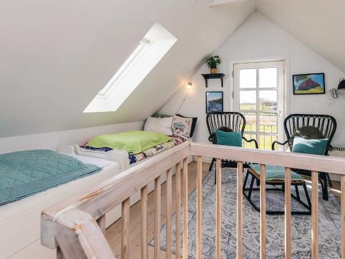 a bedroom with a bed and chairs in a attic at 6 person holiday home in Humble-By Traum in Humble