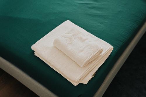 a stack of towels sitting on top of a bed at Casa Moinho Vedro in Quintiães