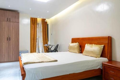 a bedroom with a bed with white sheets and yellow pillows at Résidence Madior D1 in Dakar