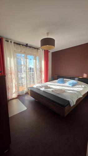 a large bed in a bedroom with a large window at Le haie vigné in Caen