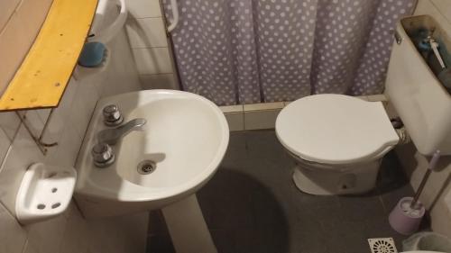a small bathroom with a white toilet and a sink at Refugio Pampa - General Pico in General Pico