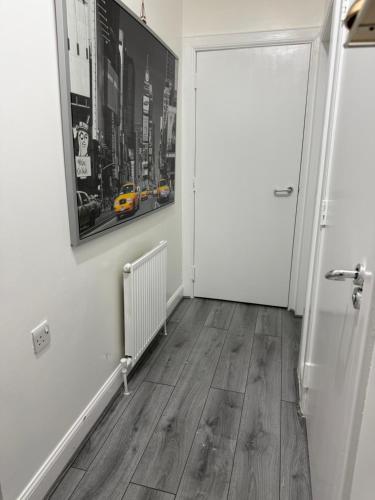 a hallway with a white door and wooden floors at Zikach Apartment Near to Glasgow Airport in Renfrew