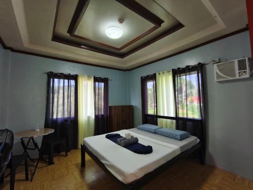 a bedroom with a bed and a table and windows at Daydream Hostel in San Juan