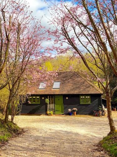 a house with a green door and some trees at Orchard Barn next to Bewl Reservoir, Ticehurst in Ticehurst