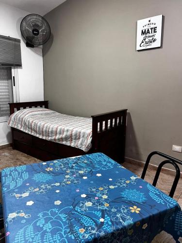 a bedroom with two beds and a blue blanket at El rincon del viajero deptos in San Francisco del Monte de Oro