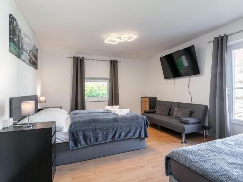 a bedroom with a bed and a couch and a tv at Gästehaus Inntal in Radfeld