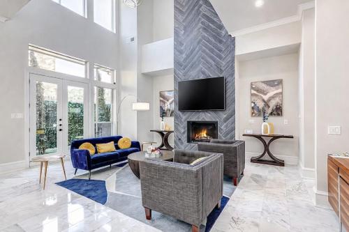a living room with a fireplace and a tv at Luxury Oak Lawn Home | Game Room, Parking, Balcony in Dallas