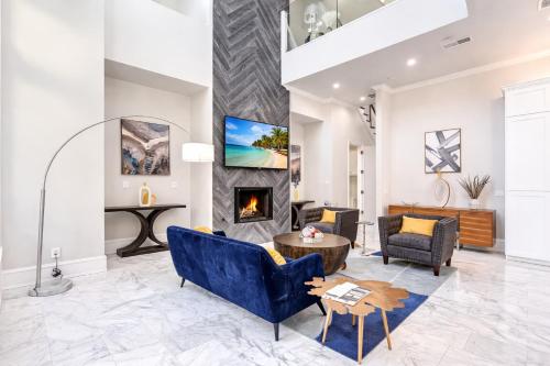 a living room with a blue couch and a fireplace at Luxury Oak Lawn Home | Game Room, Parking, Balcony in Dallas
