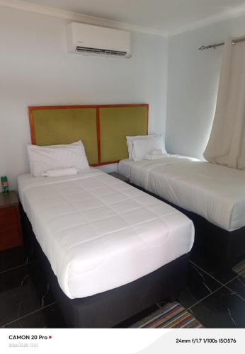 two beds sitting next to each other in a room at Raneziah Guesthouse in Kasane