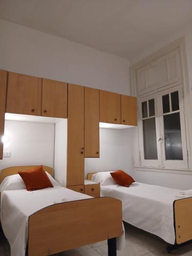 a bedroom with two beds and wooden cabinets at Pin-up hostel in Rosario