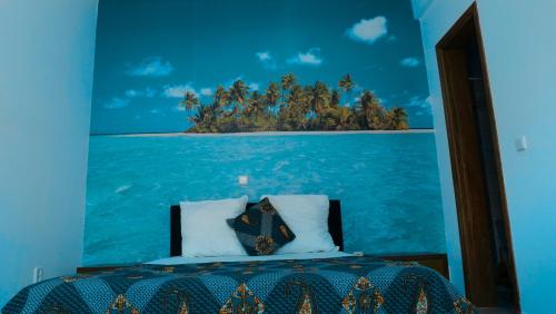 a bedroom with a painting of an island in the ocean at Appartement dépaysante T1B in Tarrafal