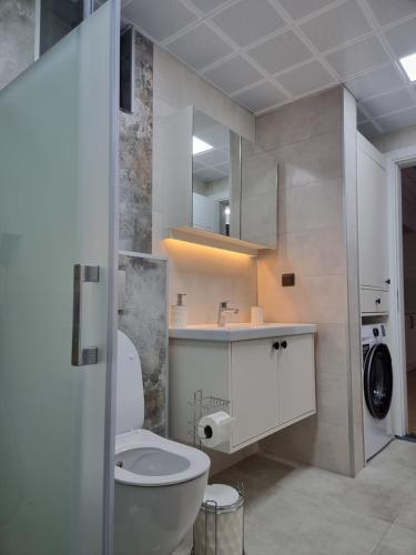 a bathroom with a white toilet and a sink at Pakiş Bungalov in Dosemealti
